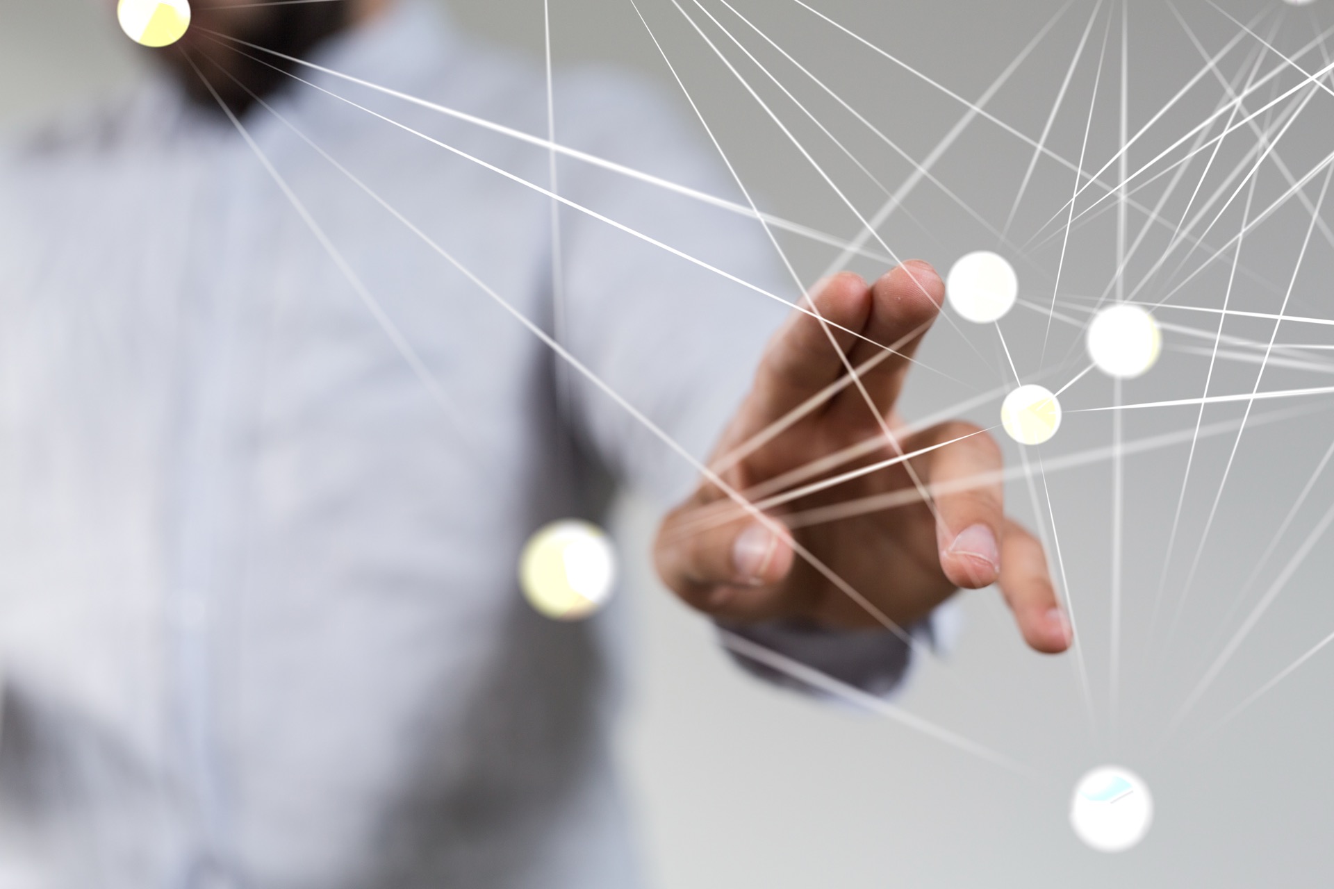 Ein Mann in hellem Hemd zeigt mit zwei Fingern und offener Hand auf einen virtuellen Graphen, der zwischen dem Betrachter und dem Mann liegt.